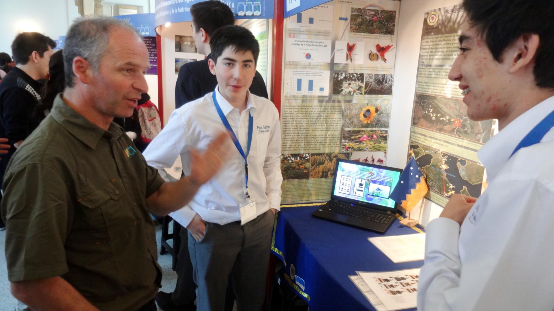 Alfredo Ugarte, jurado de la Feria Científica, conversa con los alumnos participantes.