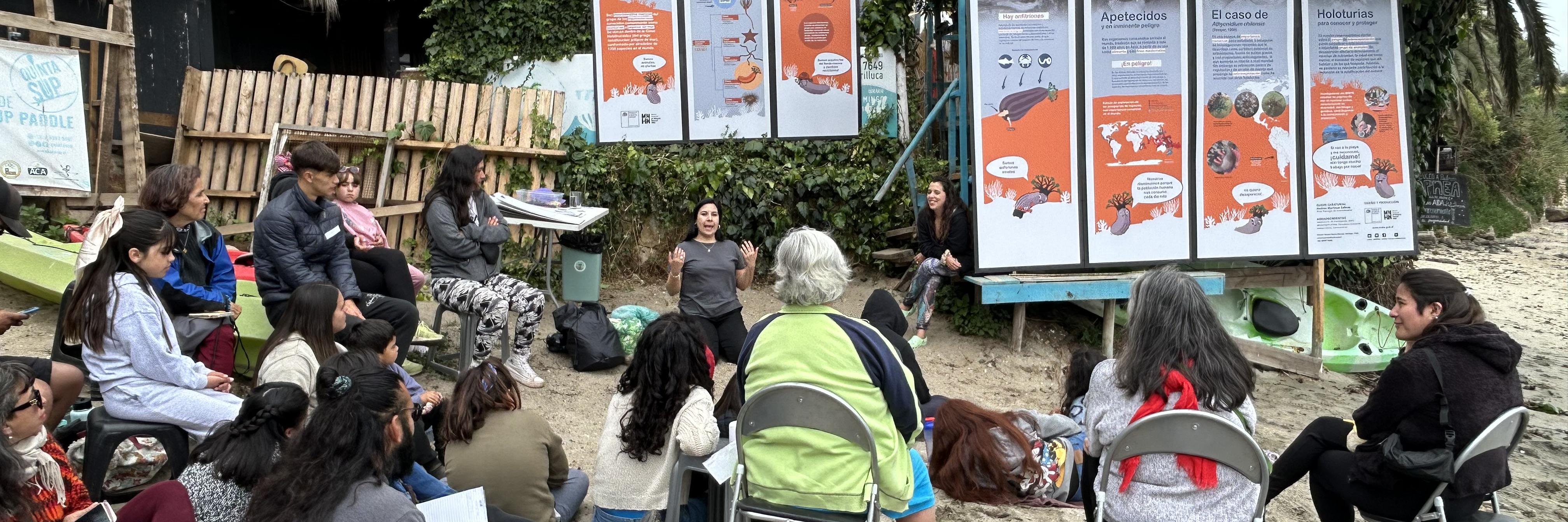 Dictando el taller: ¿quiénes son, cómo y dónde viven los pepinos de mar? En la parte posterior se observa la exhibición del MNHN (2021).
